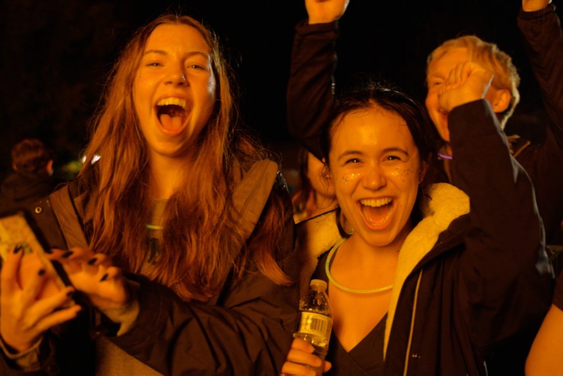 Two students smile during the Homecoming bonfire