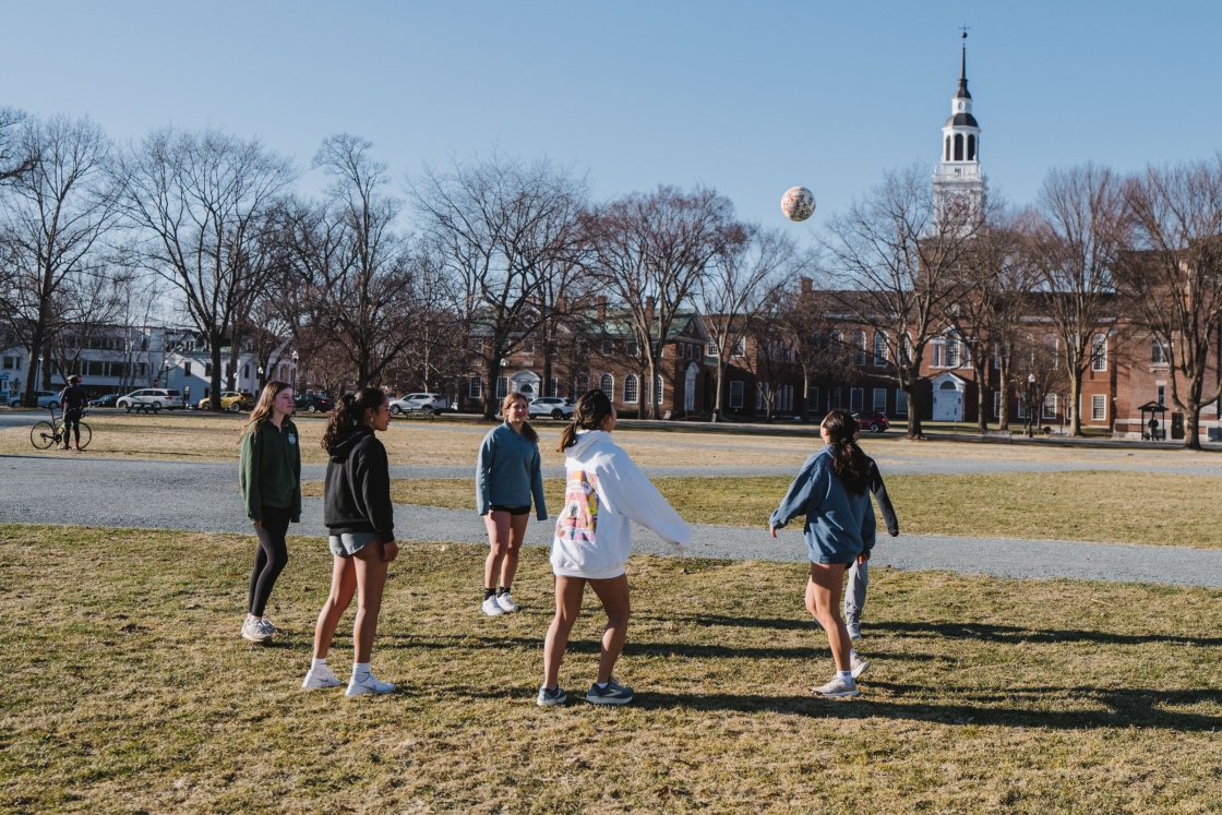 A group of women in a circle with a soccer ball