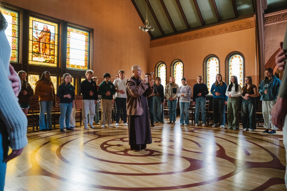 A monk leads meditation in Rollins Chapel