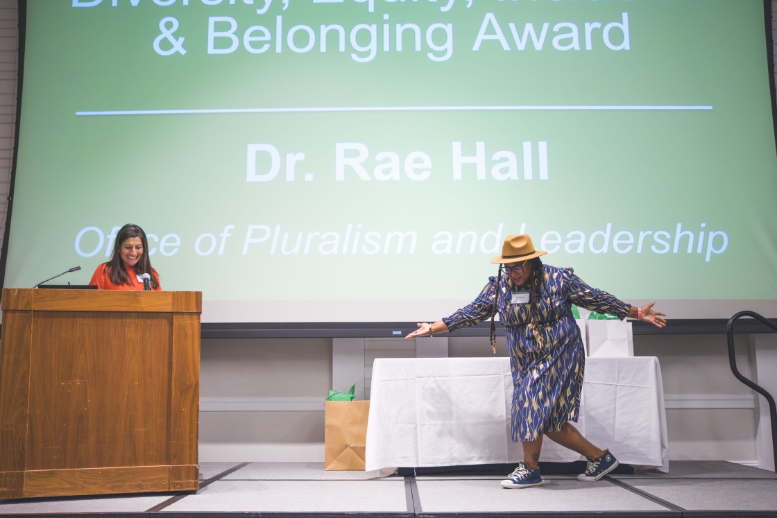Dr. Rae Hall performing a curtsy on stage