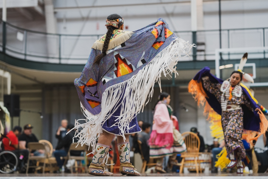 Powwow performers dancing with colorful shalls