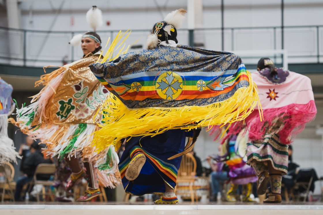 Powwow performers dancing with colorful shalls