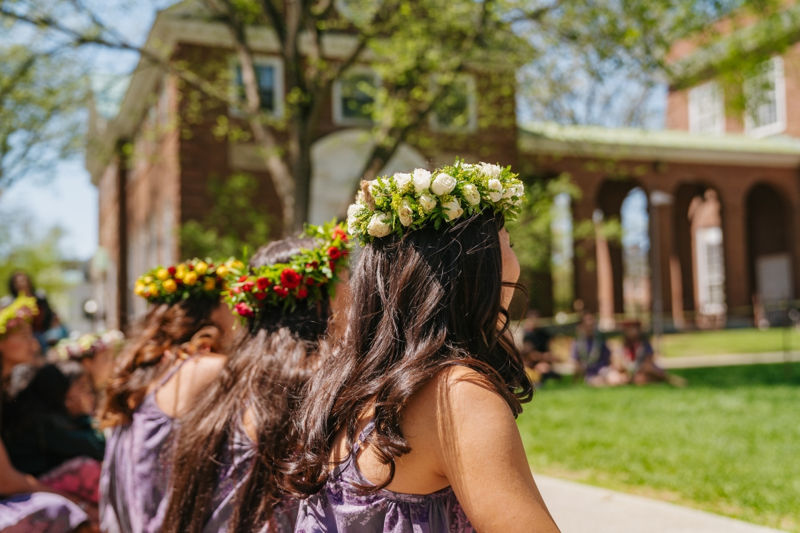Girls with garlands sit in a line