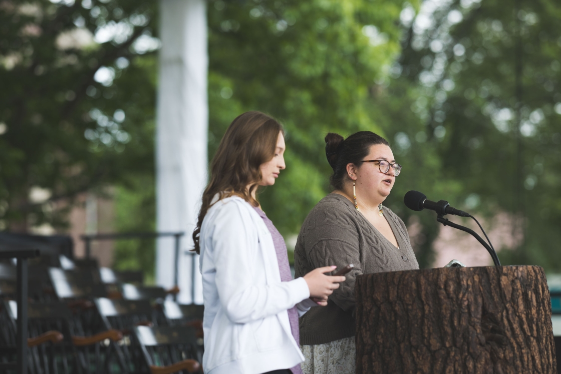 Sydney Hoose and Emma Tsosie at the mic and podium onstage