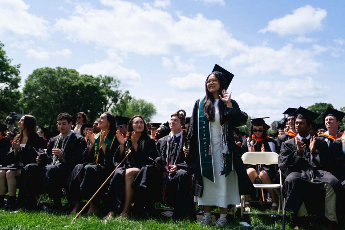 Graduate stands and waves from her seat