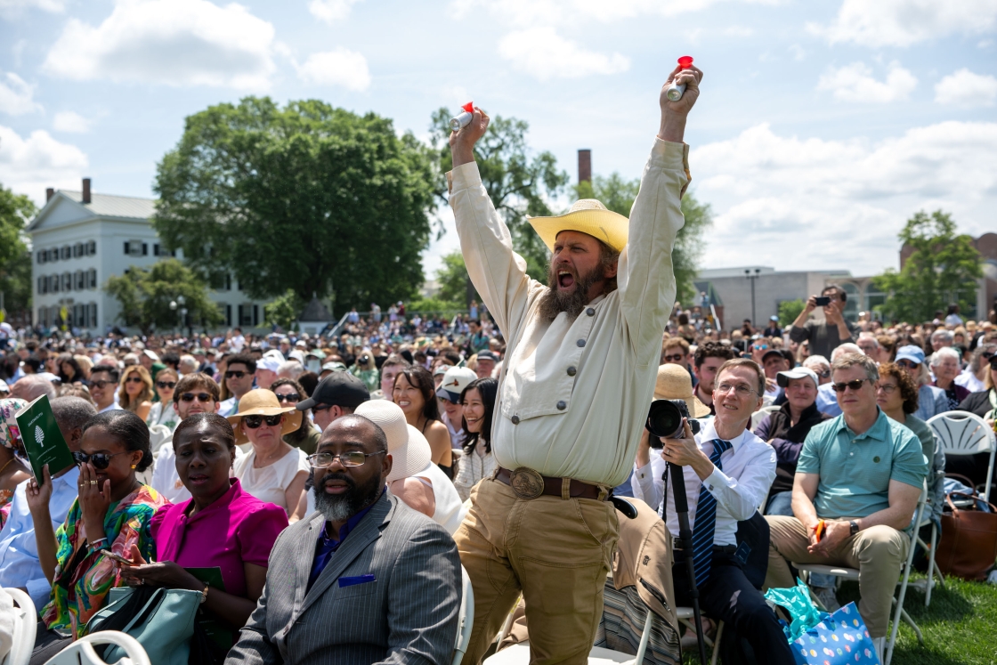 A supporter stands wearing a cowboy hat with arms in the air