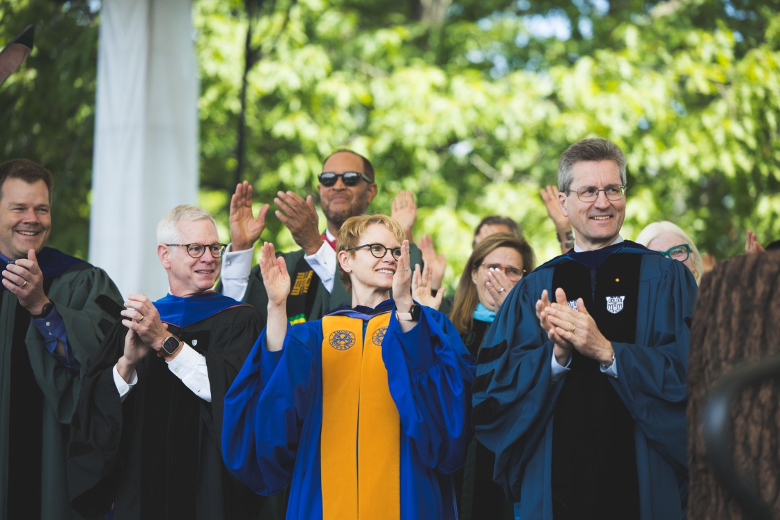 Duane Compton, Elizabeth Smith, and Dave Kotz clap ceremoniously onstage