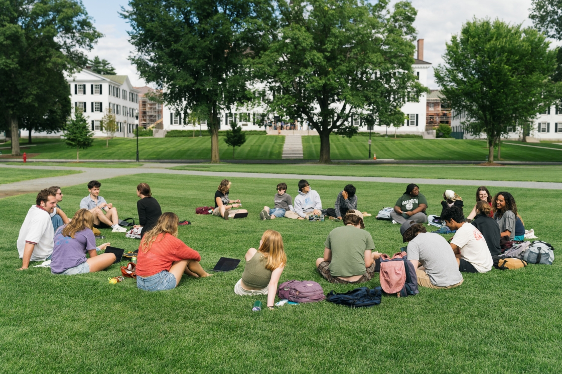 Emily Simpsons class siting in a circle on the green