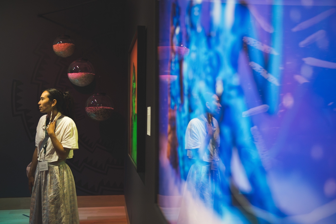 Talia Landry looking around Cara Romero's exhibit