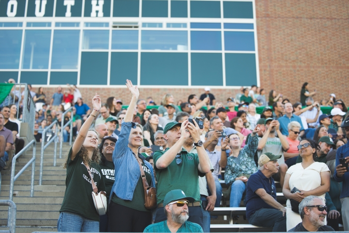 Family members waving from stadium stands