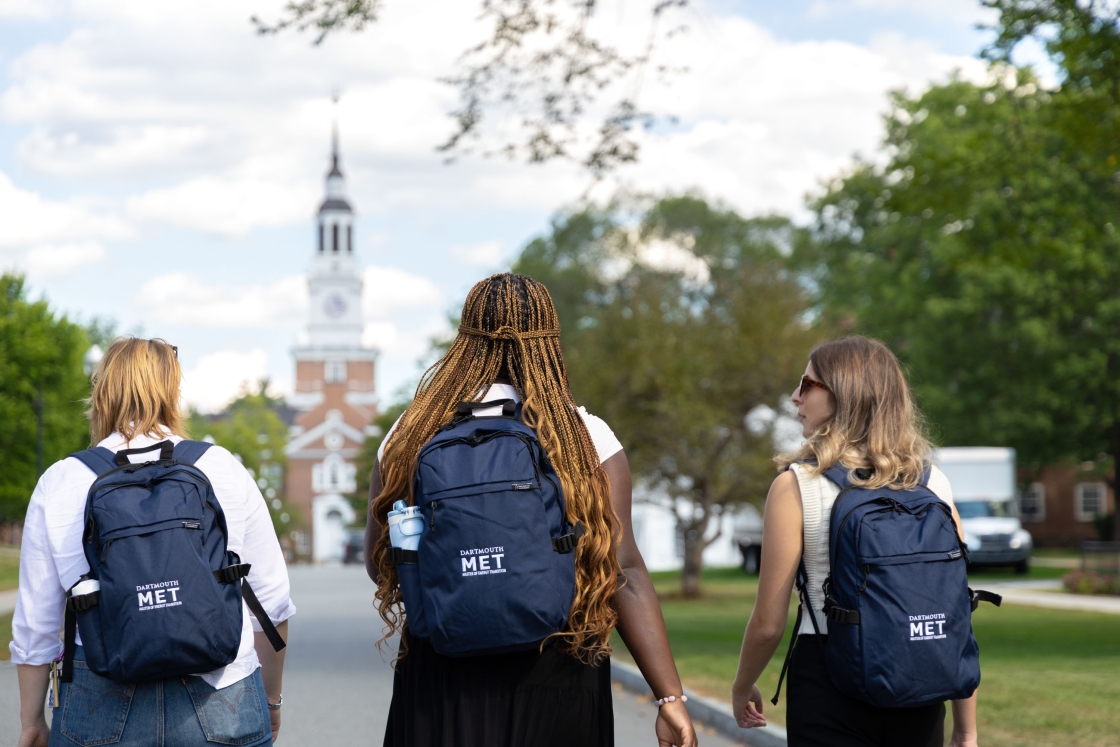 Students wearing MET backpacks walking towards Baker-Berry library