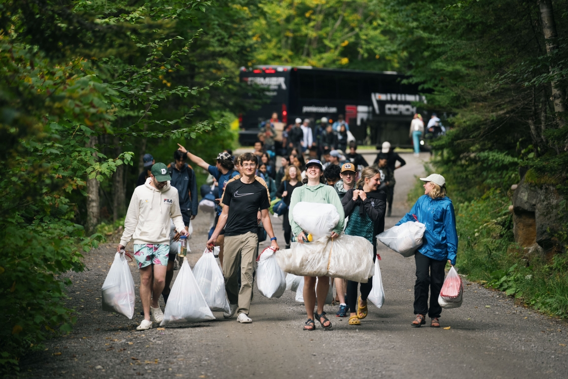 Students walk with bags of trash