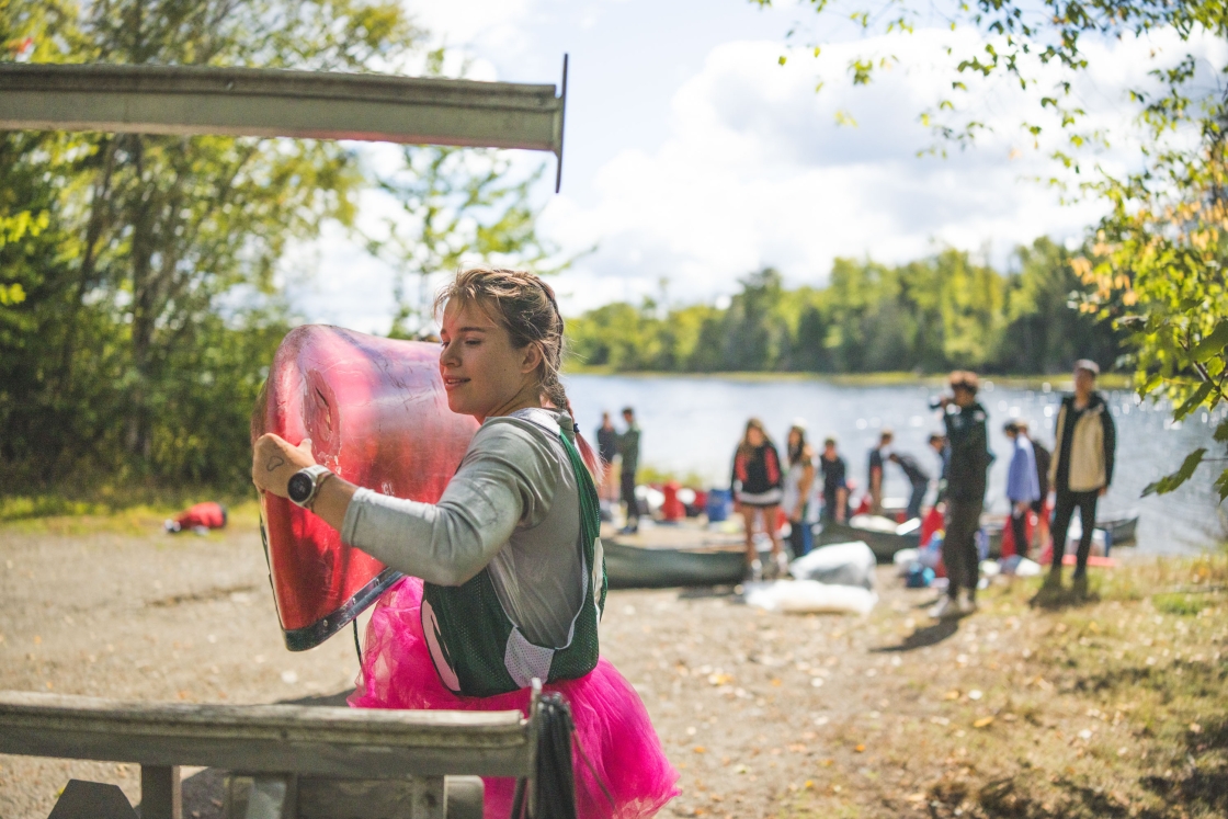 Anika Larson loading a canoe on a trailer