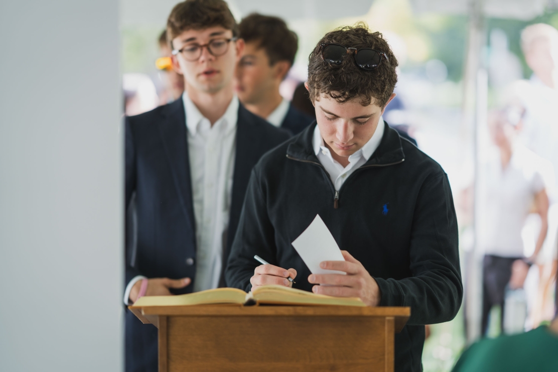 A student signs the matriculation book