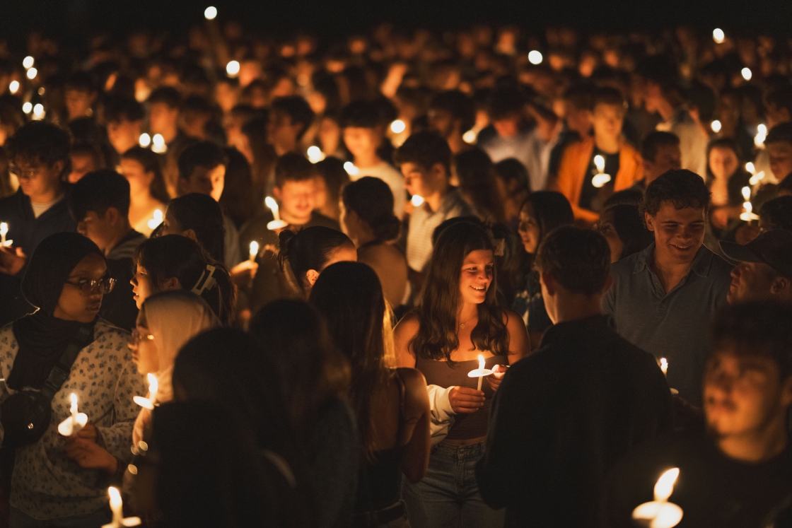 Students chat surrounded by candlelight