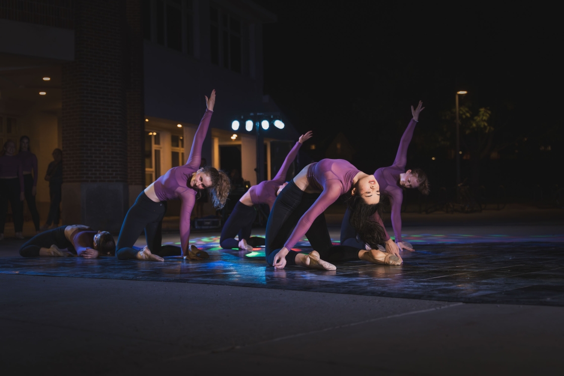 Dancers in purple and black on the ground