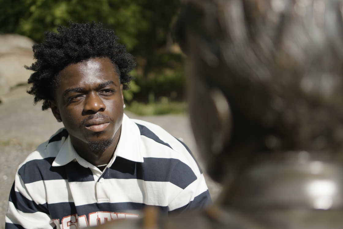Student looking at Robert Frost's statue