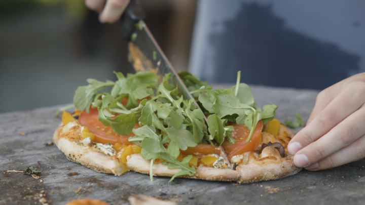 Pizza being cut with a knife