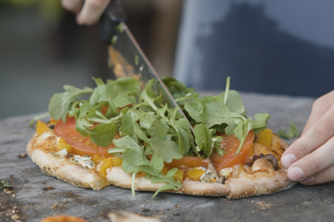Pizza being cut with a knife