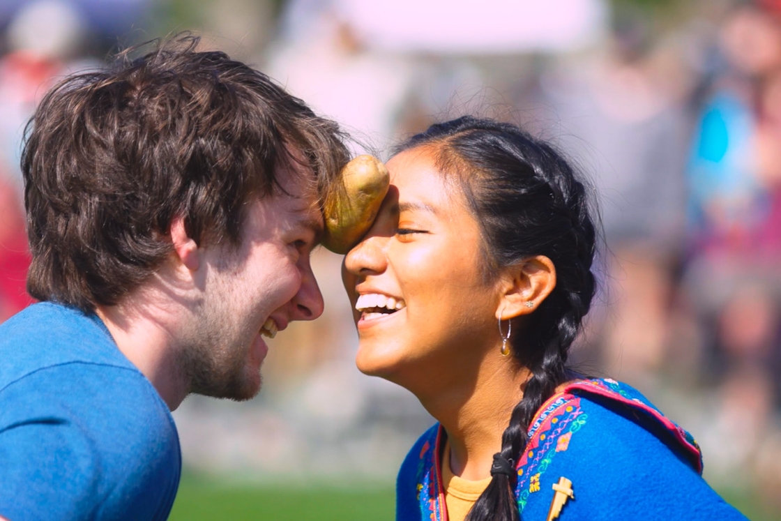 Students hold a potato between their foreheads