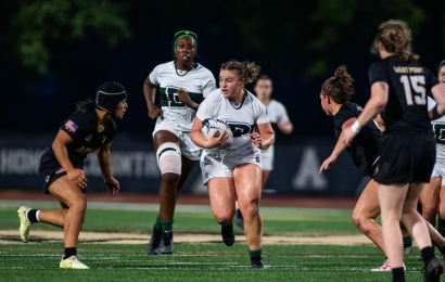 Women's rugby player running with the ball