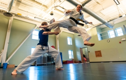 Tae kwon do student kicking through a split wooden board